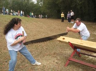 Students participate in lumberjack saw challenge at forestry event.