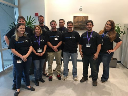 Group of students and faculty members participating in cybersecurity club event.