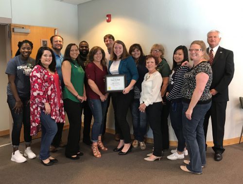 Group of diverse students and staff celebrating Haley Schipper's recognition as Kelly Services Talen.