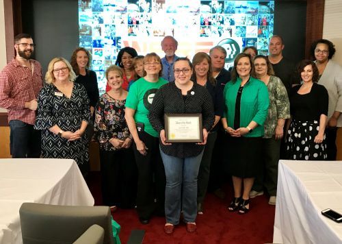 Diverse group of faculty and staff celebrating achievement at Pensacola State College, highlighting.