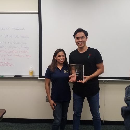College students celebrating achievement in classroom setting.