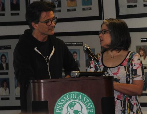 Engaged speakers discuss the book 'Uncovering the Layers' during a Pensacola State College event.