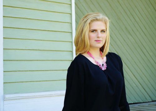 Young woman in graduation gown and cap, awarded Florida Theatrical Association grants.