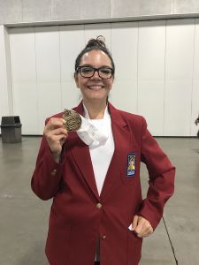 High school student proudly displays gold medal at SkillsUSA national conference.