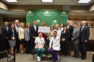 Group photo of college officials and donors celebrating nearly $40,000 scholarship donations at Pens.