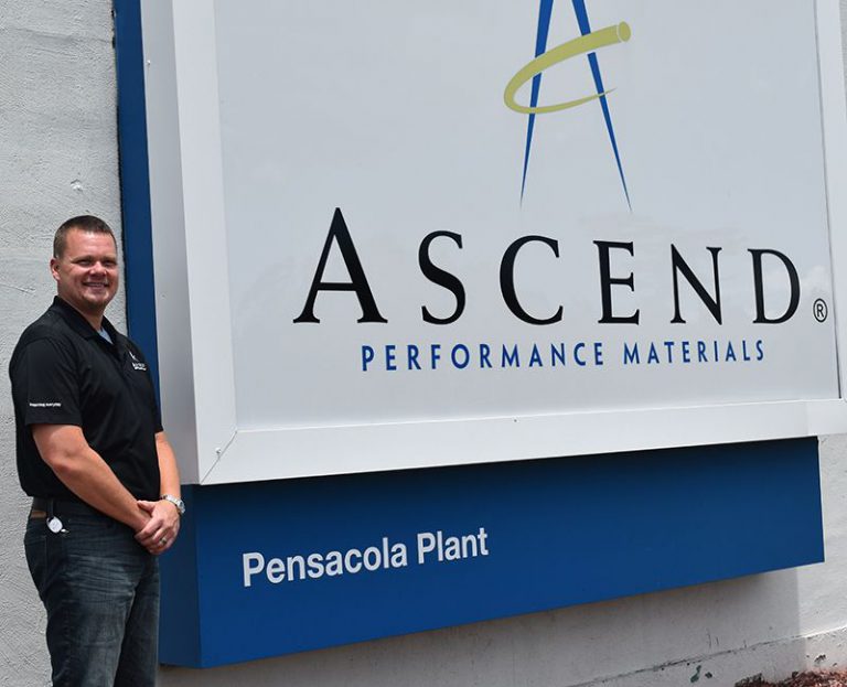 Manufacturing technician standing next to Ascend Performance Materials sign at Pensacola Plant.