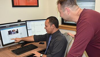 Students working together on a computer in a higher education environment.