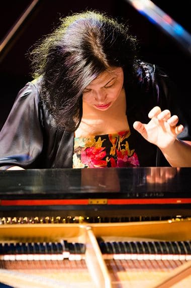 Female student playing piano during a performance at Pensacola State College.