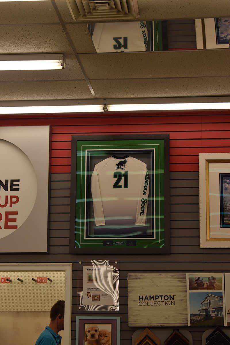 Brightly lit display showcasing a framed jersey with the number 21, part of a pirate-themed treasure.