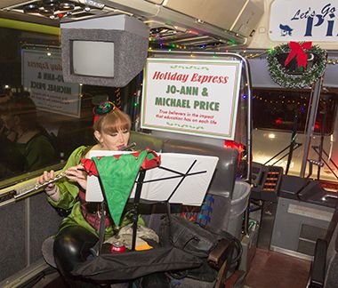 Student musician performing holiday music at Warrington campus holiday event.