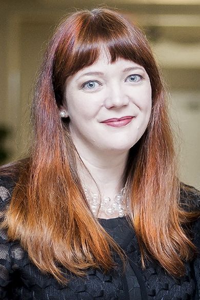 PSC professor with red hair and professional attire at PhotoNOLA photography exhibition.