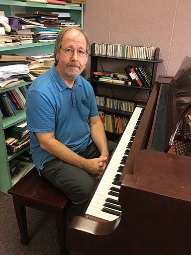 Experienced music educator demonstrating keyboard skills at Pensacola State College.