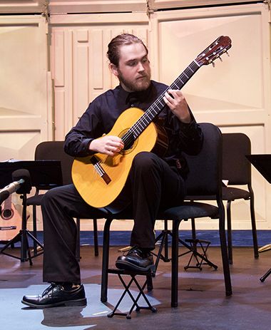 Music student performing with classical guitar at Pensacola State College.