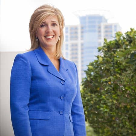 Woman in blue blazer outdoors, promoting fundraising campaigns workshop.