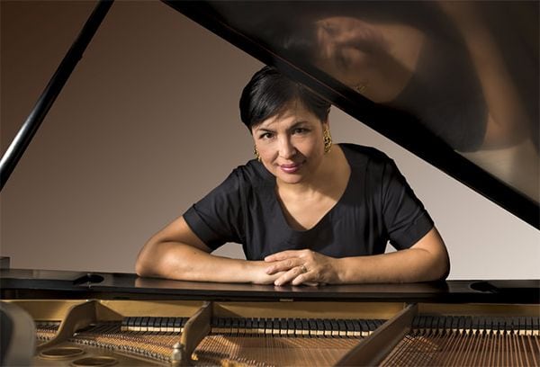 Pianist Kadisha Onalbayeva playing grand piano at Pensacola State College event.