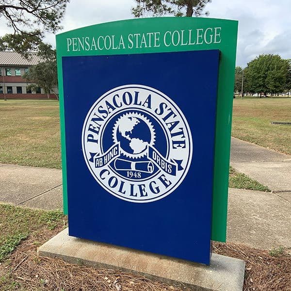 Pensacola State College sign featuring logo and campus name in outdoor setting.