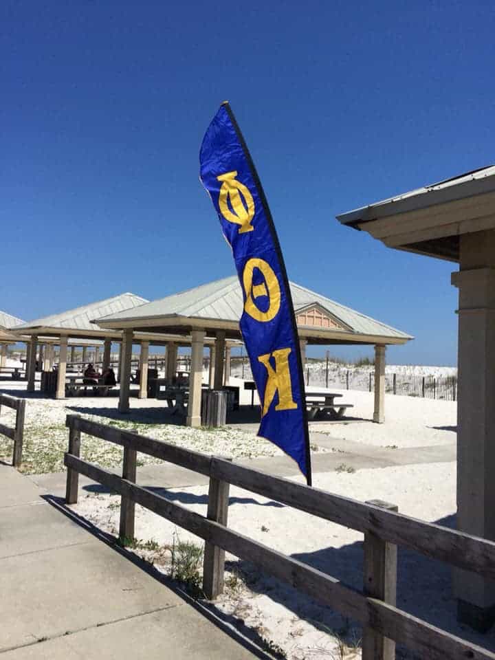 Phi Theta Kappa flag flying at Pensacola State College outdoor pavilion.