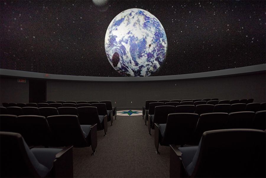 Space-themed planetarium theater with Earth projection on the dome ceiling. Planetarium theater showcasing Earth projection for educational and entertainment purposes.