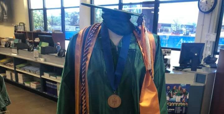 Graduation regalia including cap, gown, and medal at Pensacola State College bookstore.