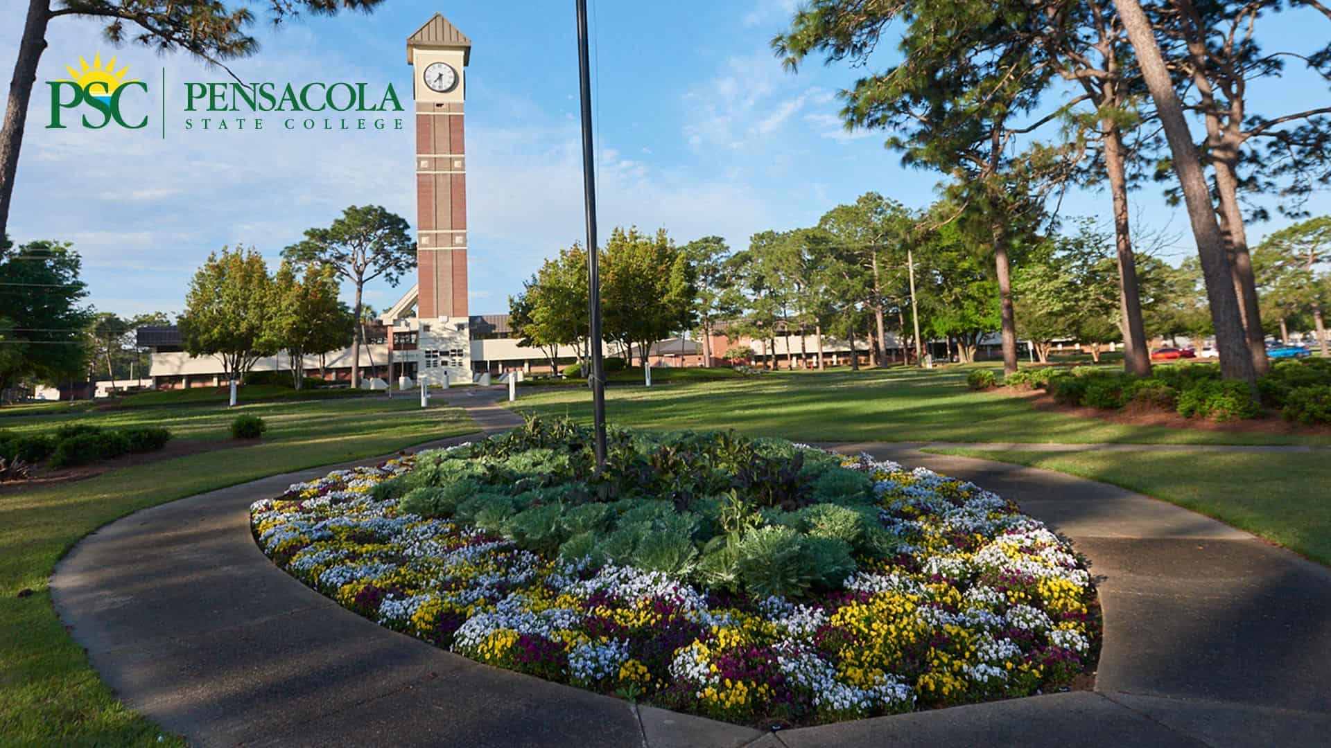 Clock Tower on Pensacola State College campus with lush greenery and colorful flowers in foreground.