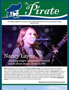 Nancy Layne performing with guitar and microphone at Pensacola State College.