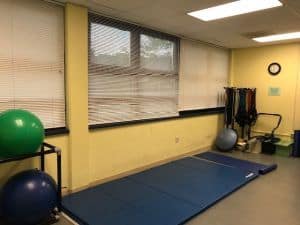 Bright indoor fitness room with mats, stability balls, and exercise equipment for student health at.