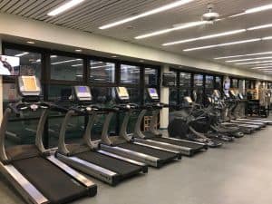 State-of-the-art cardio machines in a well-lit college gym for student fitness.