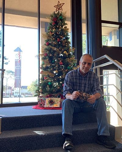 Christmas tree decorated with ornaments and lights at Pensacola State College campus.