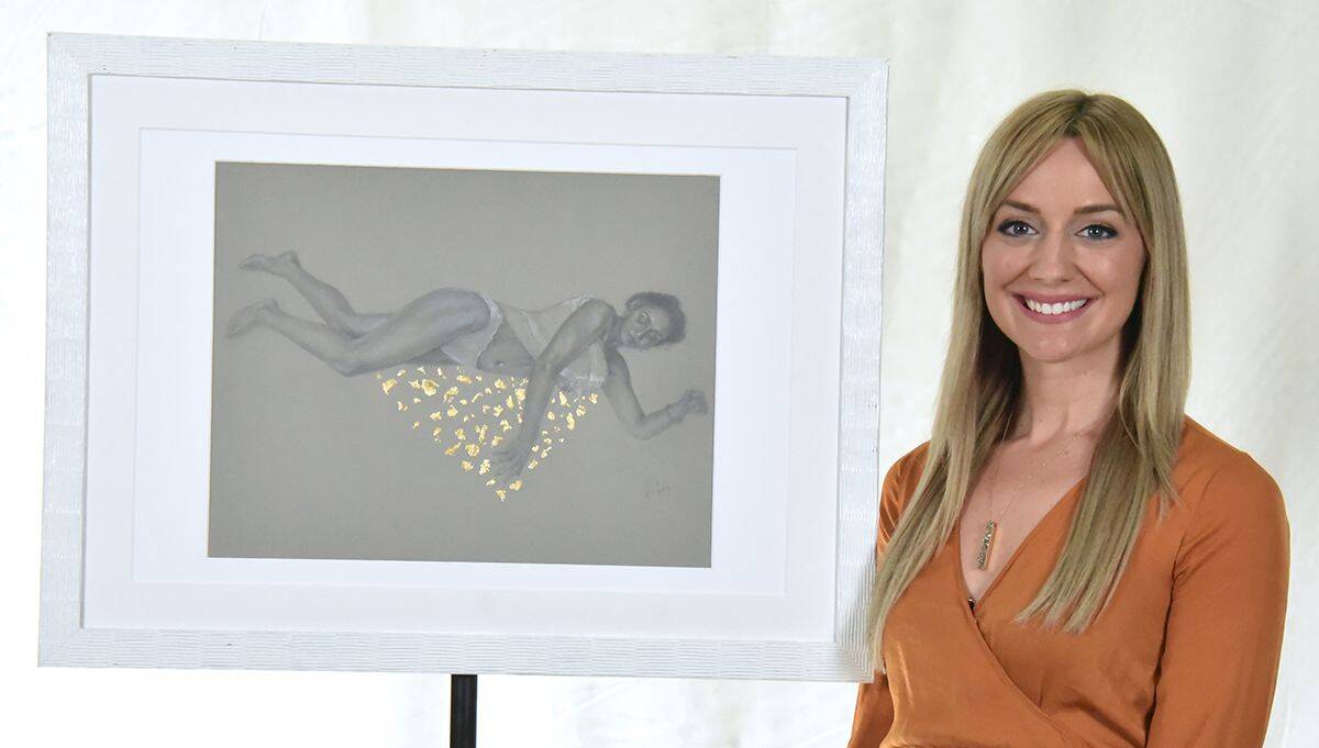 Alaina Plowdrey, new Visual Arts Department head at Pensacola State College, with artwork display.