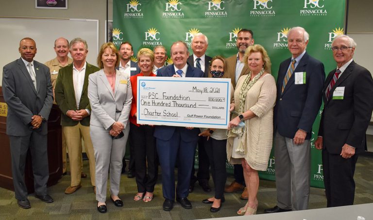Group of officials holding a large check for $100,000 from Gulf Power Foundation for PSC tech center.