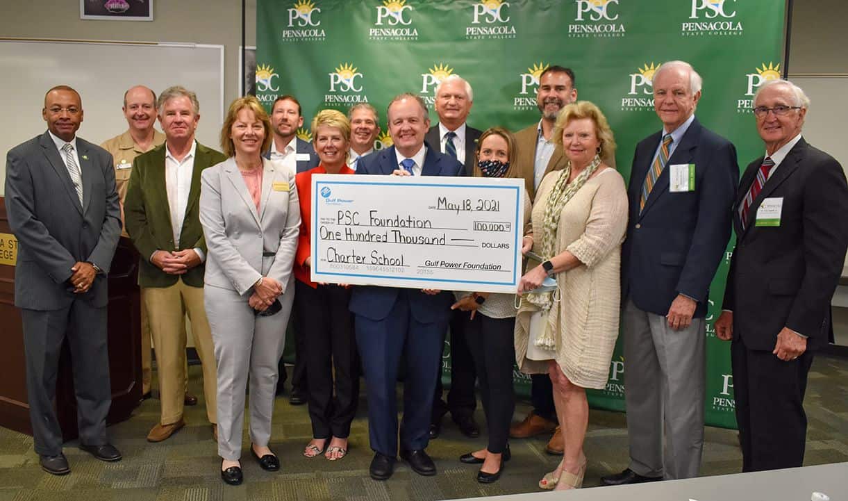 Group of officials holding a large check for $100,000 from Gulf Power Foundation for PSC tech center.