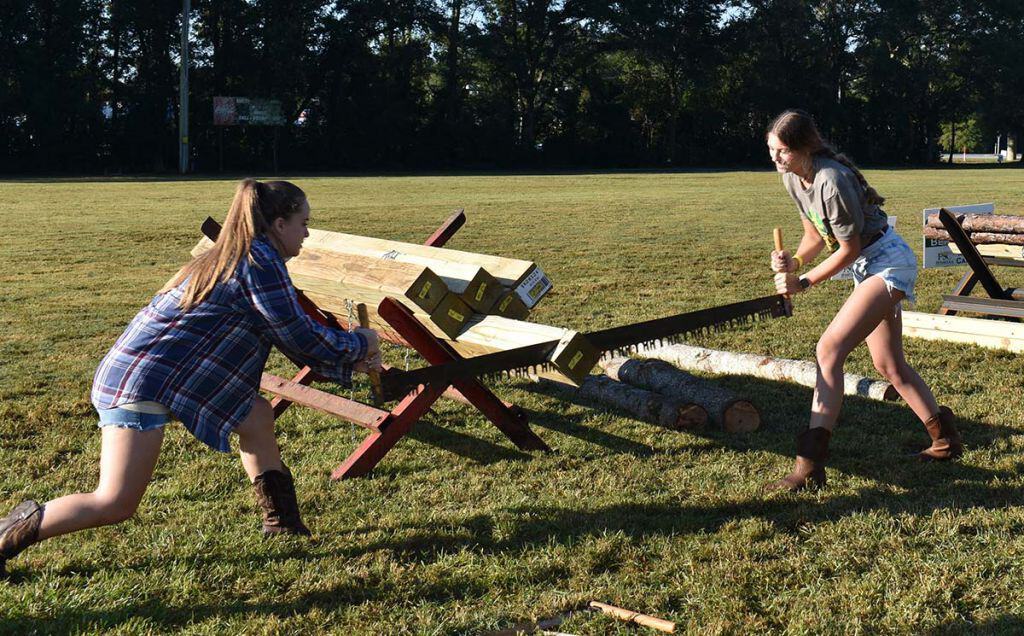 Two young women competing in lumberjack sawing contest at PSC Lumberjack Festival.