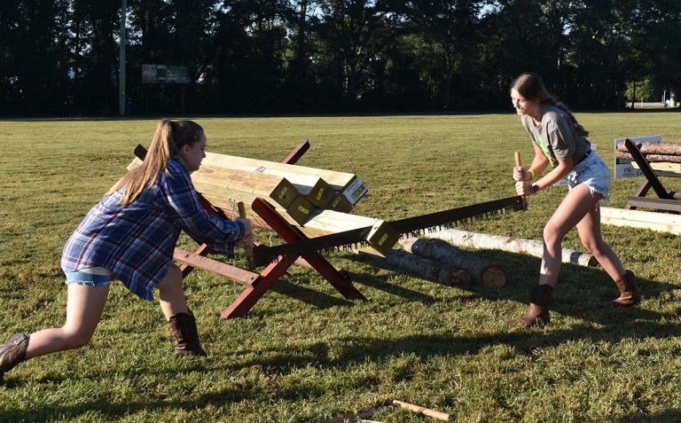 Two young women competing in log sawing event at PSC Lumberjack Festival.