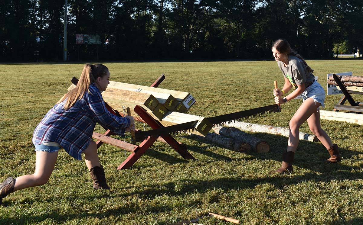 Two young women competing in log sawing event at PSC Lumberjack Festival.