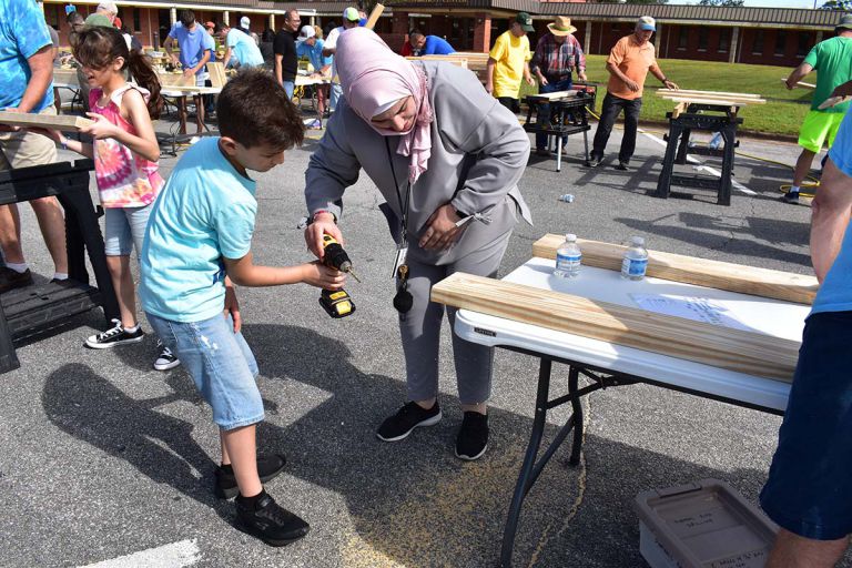 Volunteer building beds at Pensacola State College for Sleep in Heavenly Peace.