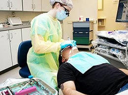 Dental student practicing emergency dental care techniques on patient.