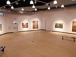 Interior view of Switzer Gallery showcasing vibrant artwork displays.