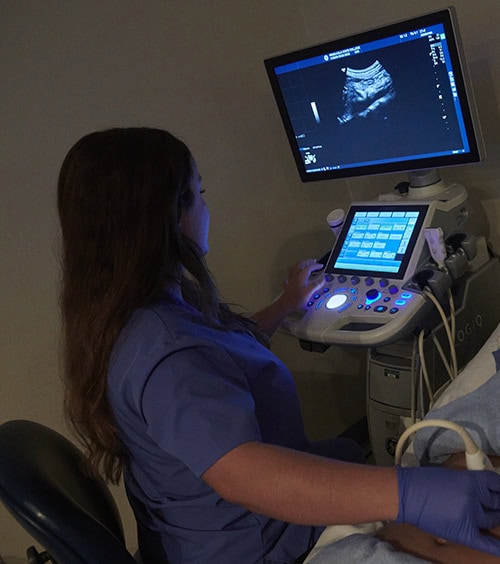 Student performing ultrasound scan during sonography training at Pensacola State College.