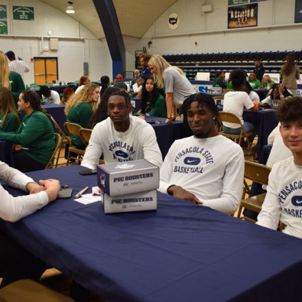 Pensacola State College basketball players at Pirate Experience event promoting athletics.