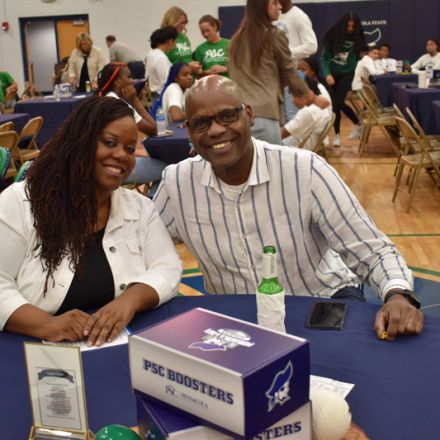 Diverse group of students and staff at PSC athletic event promoting college sports initiatives.