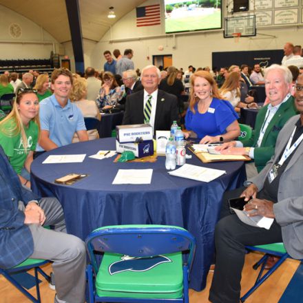 Optimized ALT text: College officials and students discuss strategic athletics planning at Pensacola.