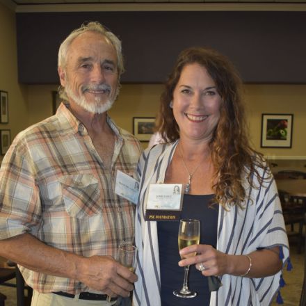 Two individuals holding glasses of champagne at a scholarship event.