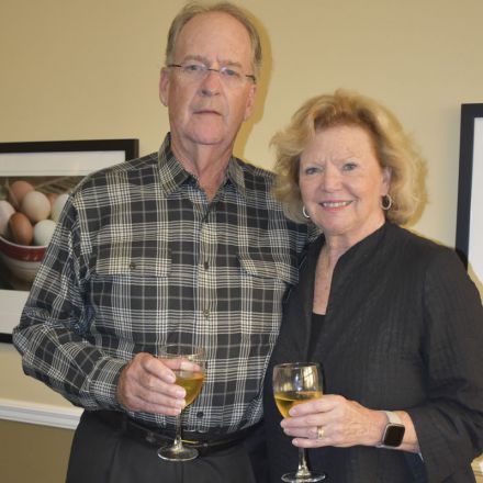 Molly McGuire scholarship recipient with college official, holding wine glasses during celebration e.