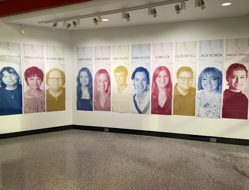 Portrait display of students' artwork at the senior exhibition.