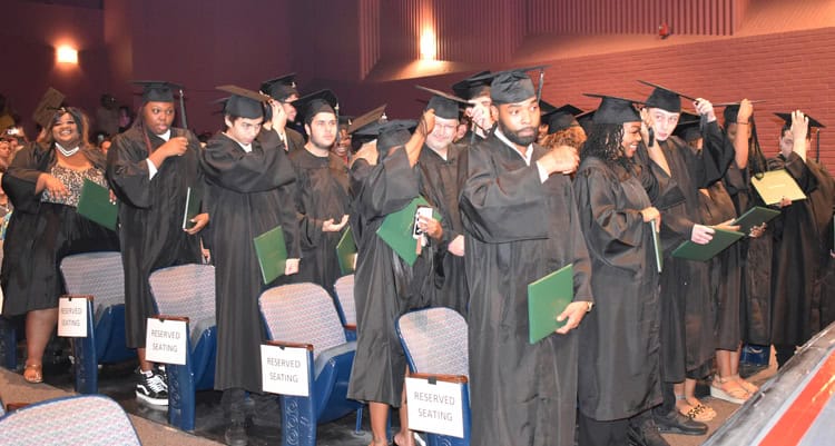 High school graduates in caps and gowns at Pensacola State College graduation event.