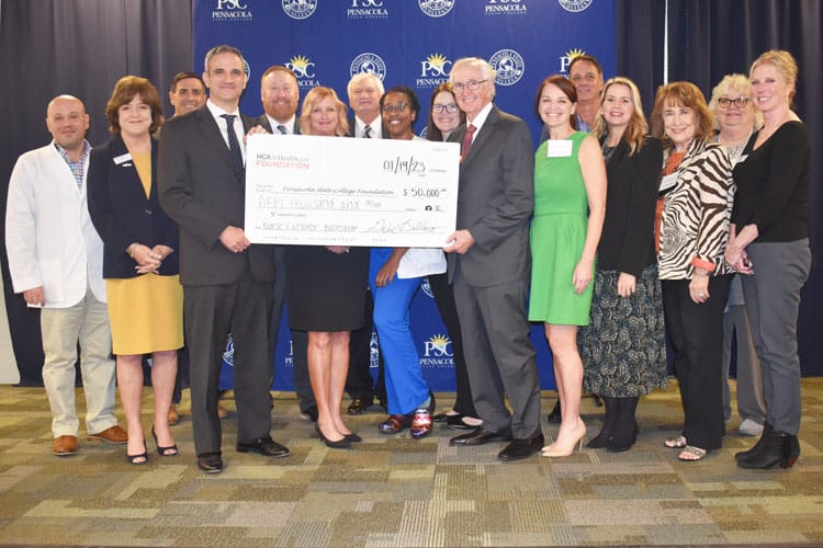 Group of diverse healthcare professionals and college officials celebrating Nurse Explorer Boot Camp.