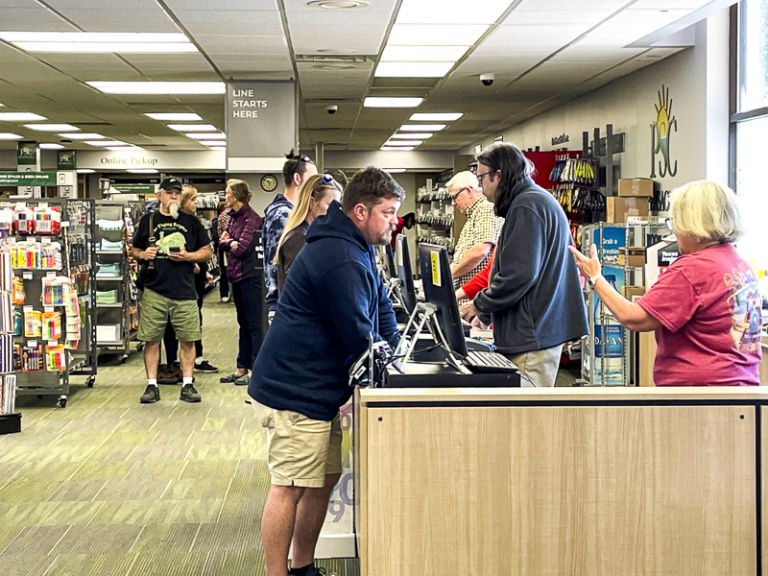 Student registering for classes during spring semester at college bookstore.