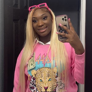 Smiling student taking a selfie in pink hoodie featuring a leopard graphic at Pensacola State Colleg.
