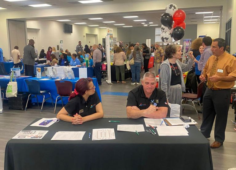 Career fair at PSC with students and professionals engaging in resume and interview workshops.
