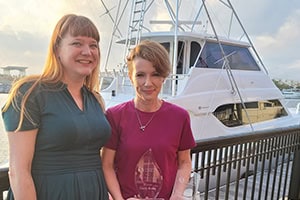 Chasity Brooks, winner of the 2023 PSC Sunset Photography Contest, stands with her award near a mari.
